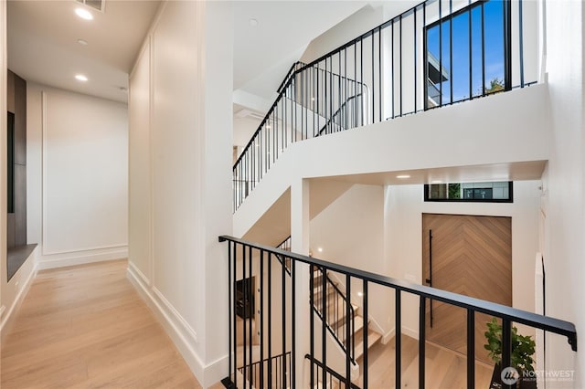 7128 NE 119th Ln, Kirkland, WA 98034 - stairs featuring wood finished floors, a towering ceiling, baseboards, and recessed lighting