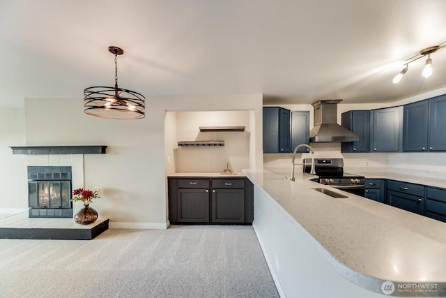 965 W Nickerson St Unit 33, Seattle, WA 98119 - kitchen with wall chimney exhaust hood, stainless steel electric range oven, light colored carpet, backsplash, and a tiled fireplace