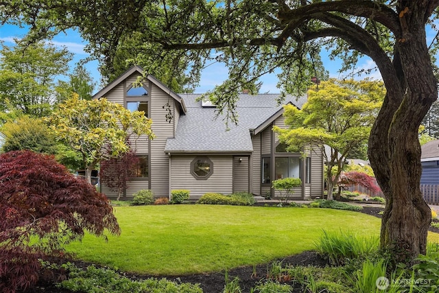 view of front facade featuring roof with shingles and a front lawn