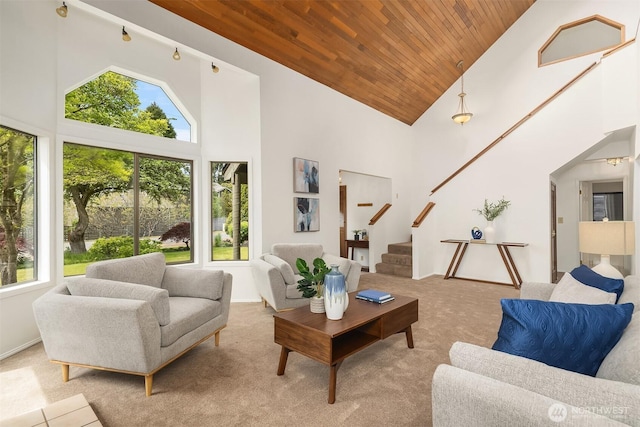 living room with healthy amount of natural light, high vaulted ceiling, wood ceiling, stairway, and carpet flooring