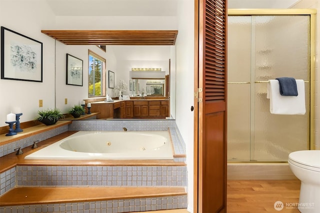 full bathroom featuring a shower stall, wood finished floors, vanity, and a tub with jets