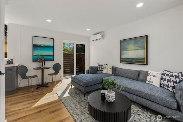 living area featuring a wall unit AC, light wood-style flooring, recessed lighting, and baseboards