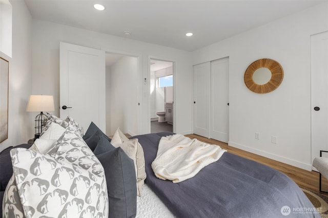 bedroom featuring wood finished floors, baseboards, recessed lighting, and connected bathroom