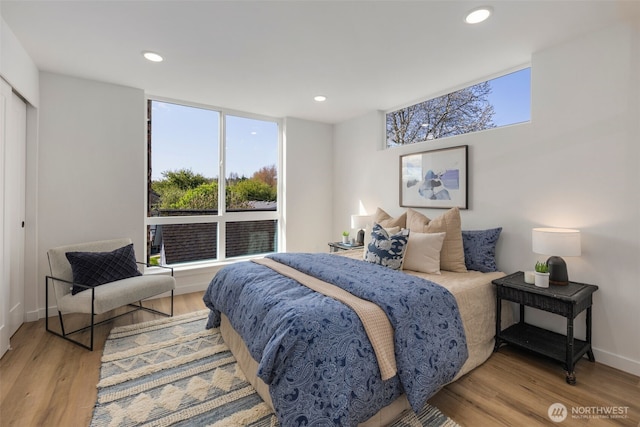 bedroom featuring wood finished floors, recessed lighting, and baseboards