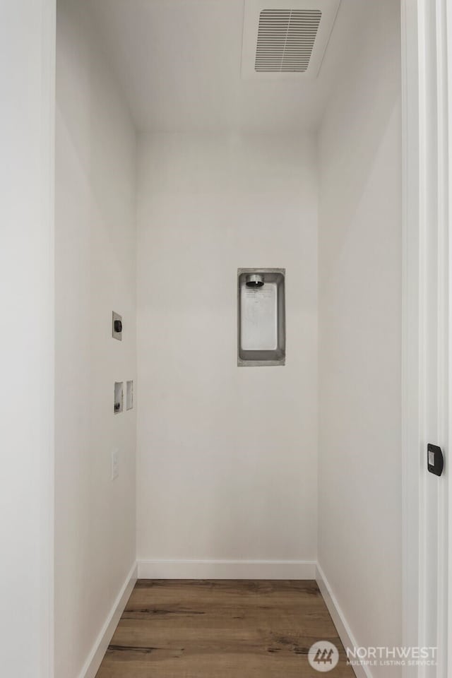 clothes washing area featuring wood finished floors, hookup for a washing machine, baseboards, and hookup for an electric dryer