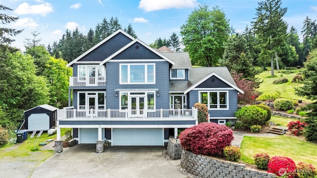 471 Dungeness Dr, Fox Island, WA 98333 - rear view of property featuring a balcony, a garage, french doors, a yard, and driveway