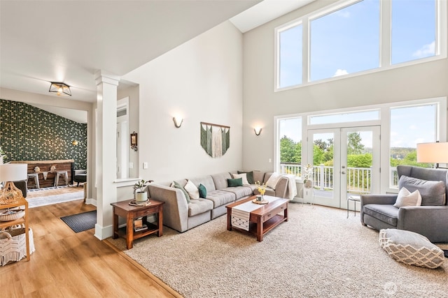 471 Dungeness Dr, Fox Island, WA 98333 - living area featuring wood finished floors, french doors, decorative columns, a towering ceiling, and baseboards