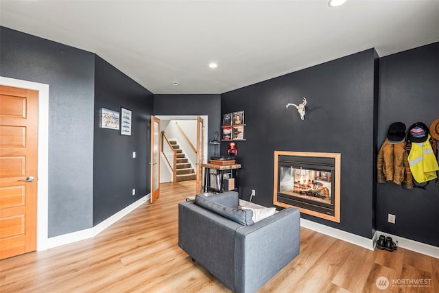 471 Dungeness Dr, Fox Island, WA 98333 - living area with wood finished floors, a multi sided fireplace, stairs, baseboards, and recessed lighting