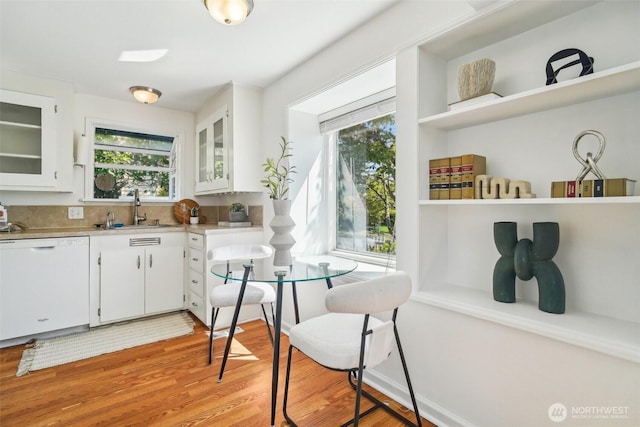 10229 35th Ave SW, Seattle, WA 98146 - kitchen with dishwasher, a sink, light wood-style floors, light countertops, and white cabinetry