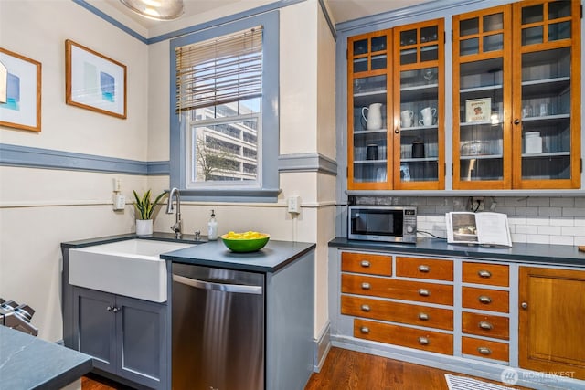 615 Boren Ave Unit 11, Seattle, WA 98104 - kitchen featuring stainless steel appliances, a sink, glass insert cabinets, tasteful backsplash, and dark wood-type flooring