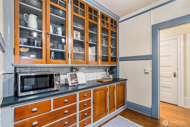 615 Boren Ave Unit 11, Seattle, WA 98104 - bar with stainless steel microwave, dark wood-style flooring, backsplash, and baseboards