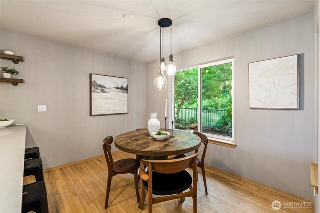 dining area with light wood-style flooring and baseboards