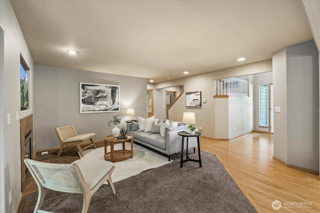 living area featuring light wood-style flooring, recessed lighting, and a fireplace