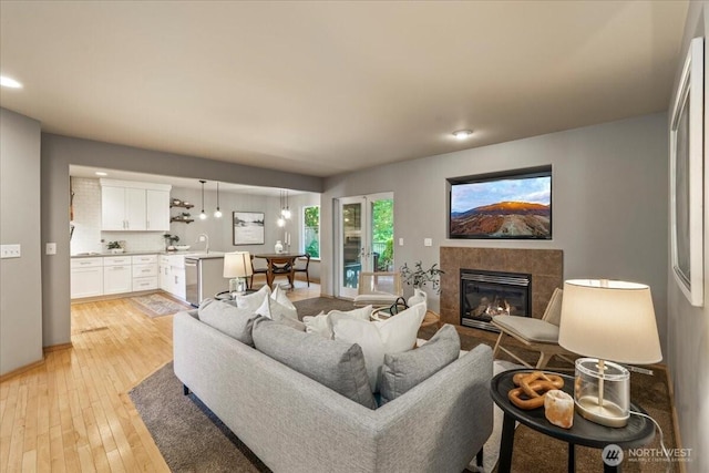 living room featuring light wood finished floors, a fireplace, and recessed lighting