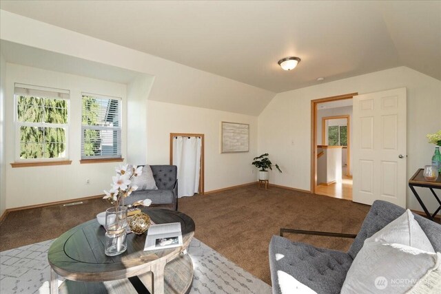 living area with carpet flooring, lofted ceiling, and baseboards