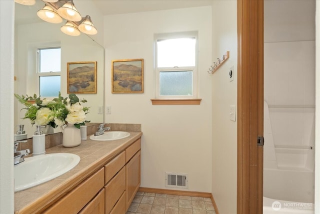 bathroom featuring double vanity and baseboards
