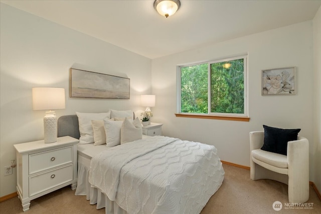 bedroom with light colored carpet and baseboards