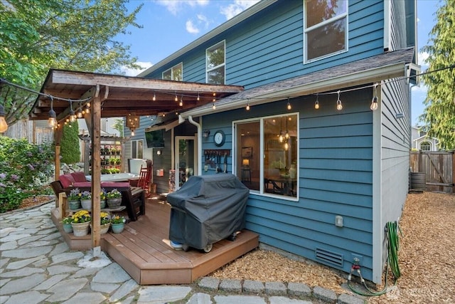 back of property featuring fence, a deck, and a patio