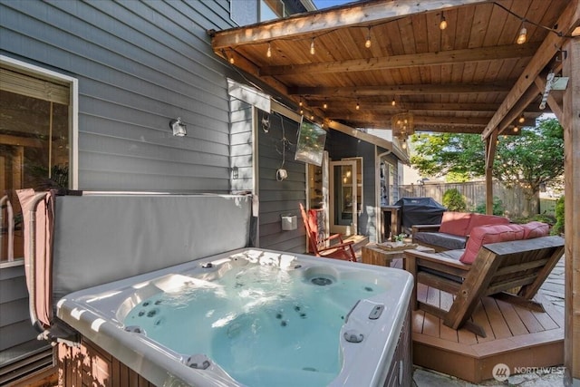 view of patio / terrace featuring a hot tub, fence, and a grill