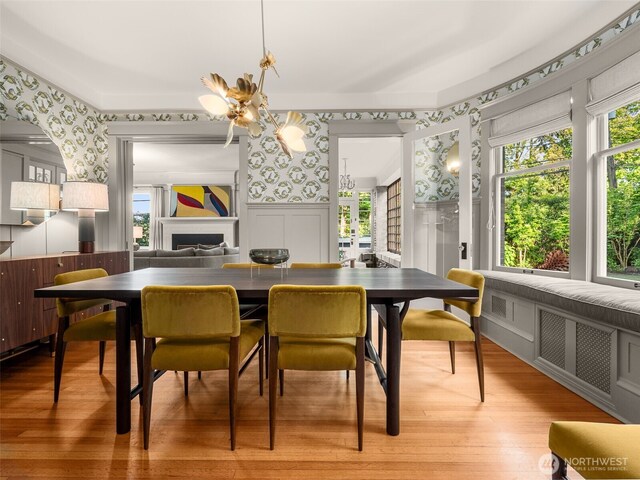 2161 E Interlaken Blvd, Seattle, WA 98112 - dining space with wallpapered walls, healthy amount of natural light, wood finished floors, a fireplace, and a chandelier