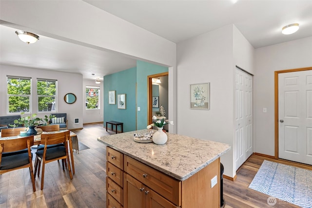 19554 Jensen Way NE, Poulsbo, WA 98370 - kitchen featuring a kitchen island, wood finished floors, open floor plan, and light stone countertops