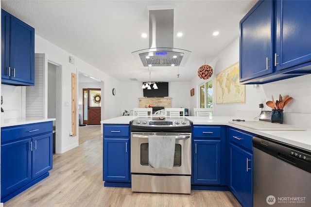 19045 Nutmeg St SW, Rochester, WA 98579 - kitchen with stainless steel appliances, island range hood, a peninsula, blue cabinetry, and recessed lighting