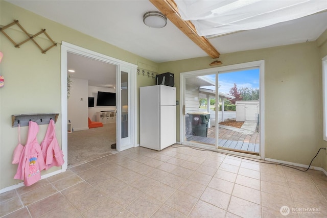 19045 Nutmeg St SW, Rochester, WA 98579 - empty room with light tile patterned floors, beamed ceiling, and baseboards