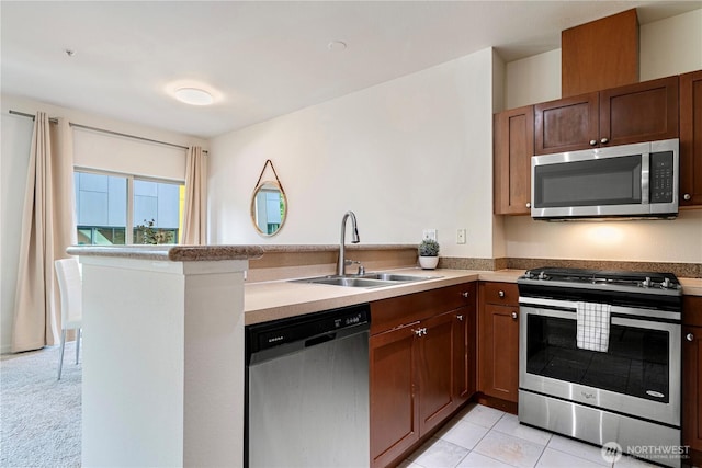 1000 Aurora Ave N Unit 311, Seattle, WA 98109 - kitchen with stainless steel appliances, a sink, a peninsula, and light countertops