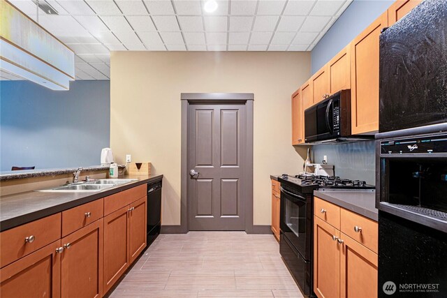 1000 Aurora Ave N Unit 311, Seattle, WA 98109 - kitchen with black appliances, a sink, dark countertops, and light wood-type flooring