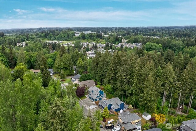 view of property location with a forest and nearby suburban area