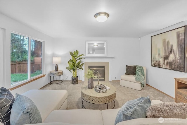 carpeted living area with a fireplace with flush hearth and baseboards