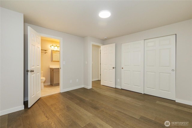 12605 Monte Cristo Way, Granite Falls, WA 98252 - unfurnished bedroom featuring dark wood finished floors, baseboards, ensuite bath, and a closet