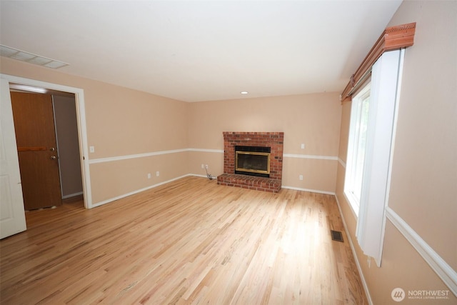 11857SE 321st Pl, Auburn, WA 98092 - unfurnished living room with light wood finished floors, a brick fireplace, and baseboards