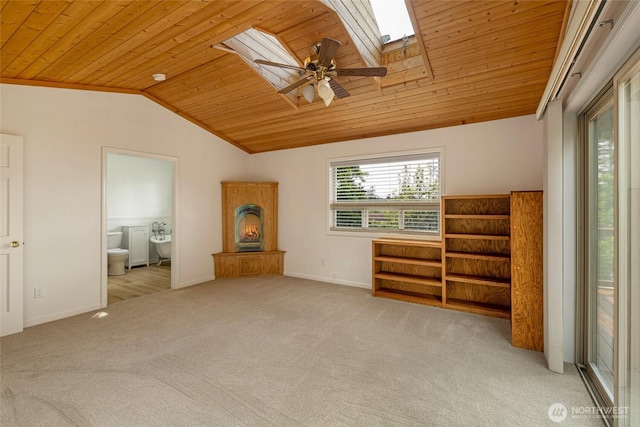 255 Alder St, Orcas Island, WA 98245 - carpeted spare room with a skylight, lofted ceiling, wooden ceiling, a lit fireplace, and baseboards
