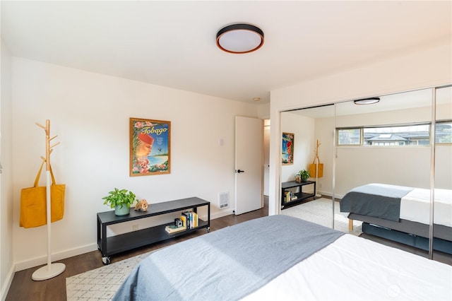 bedroom featuring a closet, baseboards, and wood finished floors