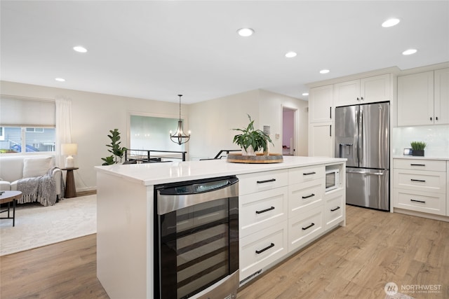 20113 4th Pl S, Des Moines, WA 98198 - kitchen featuring stainless steel fridge, beverage cooler, light wood-style flooring, light countertops, and white cabinets