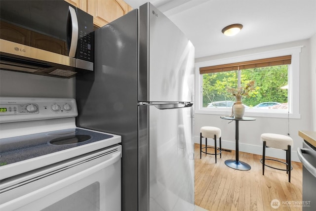 664 W Emerson St Unit A, Seattle, WA 98119 - kitchen with appliances with stainless steel finishes, light wood-type flooring, and baseboards