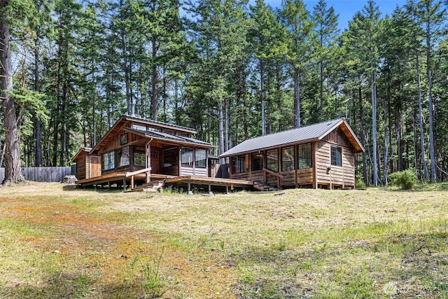 35 N Airport Way, Stuart Island, WA 98250 - view of front of property featuring metal roof, a wooden deck, and a forest view
