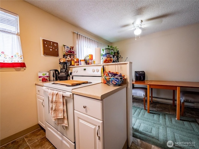 kitchen with white electric stove, healthy amount of natural light, a ceiling fan, a textured ceiling, and light countertops