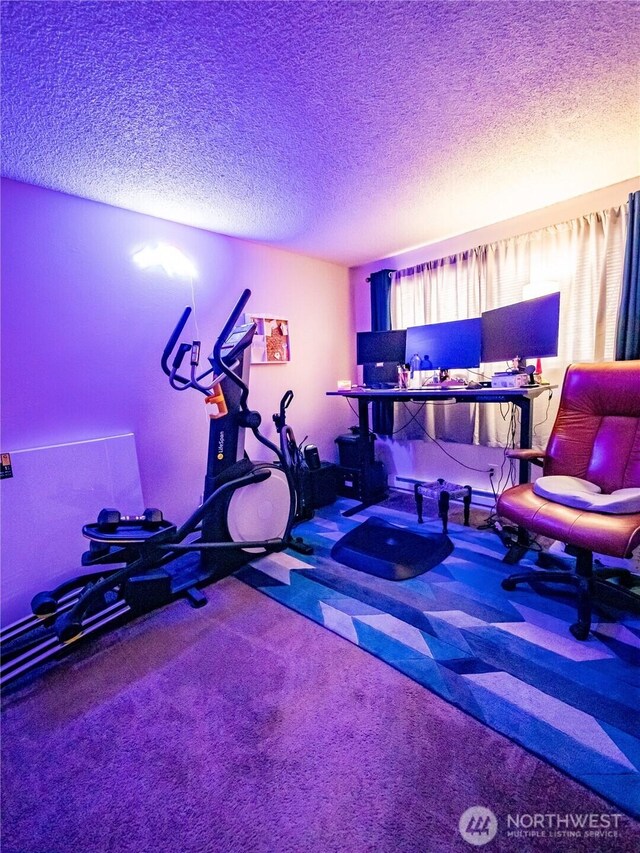 exercise area featuring a textured ceiling and carpet floors