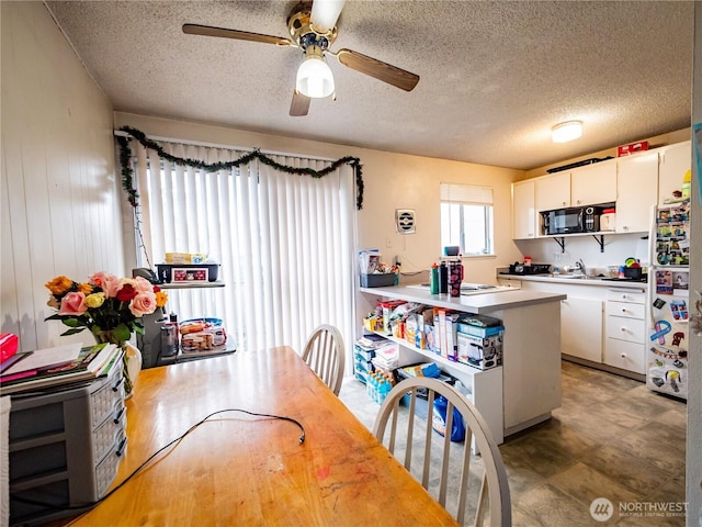 dining area with a textured ceiling and ceiling fan