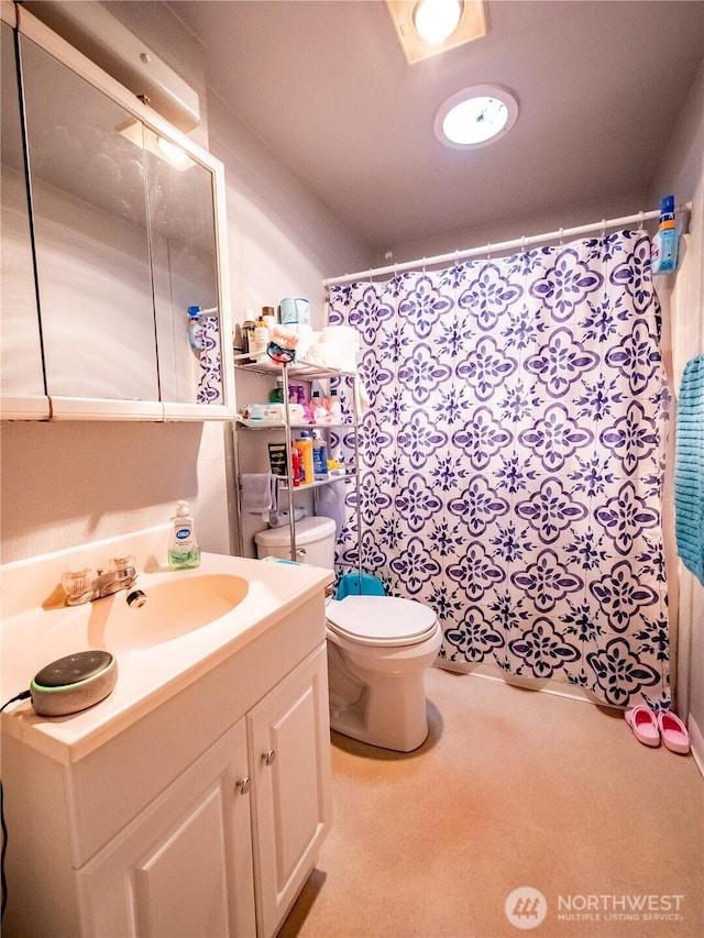 bathroom with toilet, vanity, and curtained shower