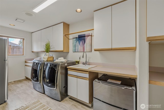 laundry area featuring independent washer and dryer and cabinet space
