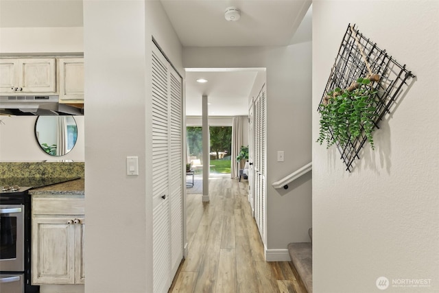 hall with light wood-style floors, stairway, baseboards, and recessed lighting