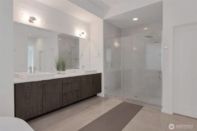 bathroom featuring a stall shower, double vanity, tile patterned flooring, and recessed lighting