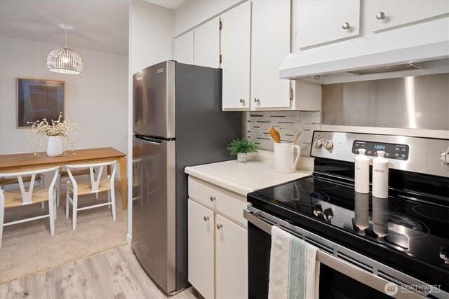 4540 8th Ave NE Unit 104, Seattle, WA 98105 - kitchen with appliances with stainless steel finishes, under cabinet range hood, light wood-style flooring, white cabinets, and light countertops