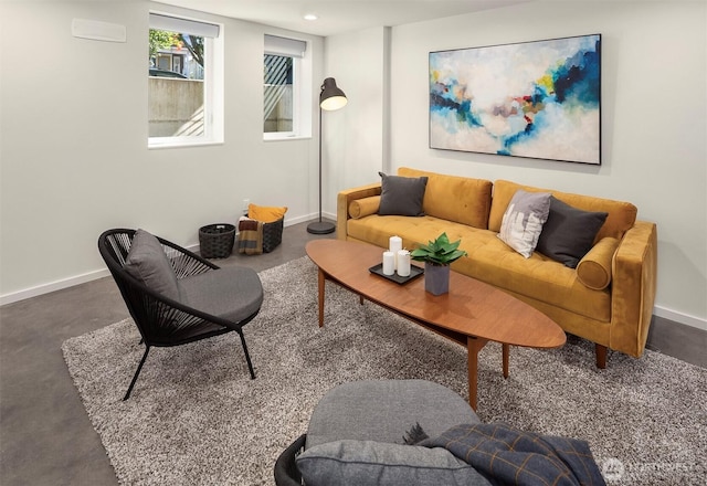 living area featuring baseboards and finished concrete flooring