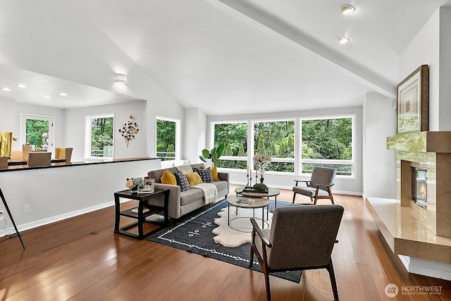 11950 NE 36th Pl, Bellevue, WA 98005 - living area featuring vaulted ceiling, wood finished floors, a fireplace, and baseboards