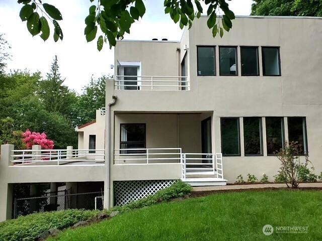 11950 NE 36th Pl, Bellevue, WA 98005 - rear view of property with stucco siding, a balcony, and a lawn