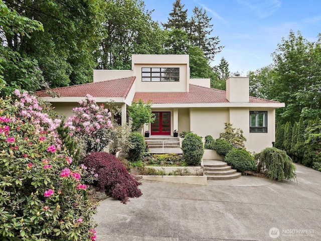 11950 NE 36th Pl, Bellevue, WA 98005 - contemporary house with french doors, a chimney, a tiled roof, and stucco siding